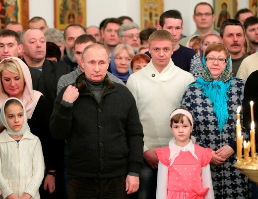 Putin is said to attend a ceremony at a monastery in the Novgorod region on January 6, 2017. On the left, the blonde woman identified as an extra.  The Kremlin took the picture.
